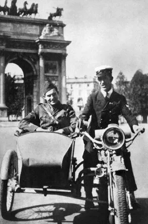 Hemingway nel 1918 nel carrozzino di un sidecar Indian Power Plus bicilindrico dell’esercito statunitense guidato da un amico davanti all’Arco della Pace di Milano