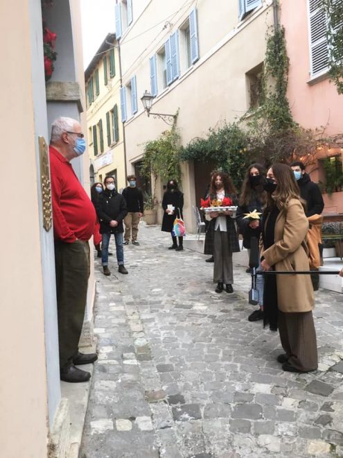 Poesie a domicilio: un signore di Santarcangelo di Romagna apre la propria porta per ricevere il dono